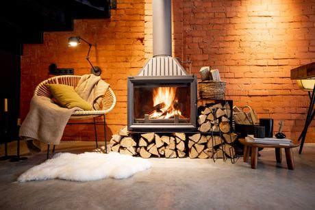 a living room with a fireplace and a pile of logs .