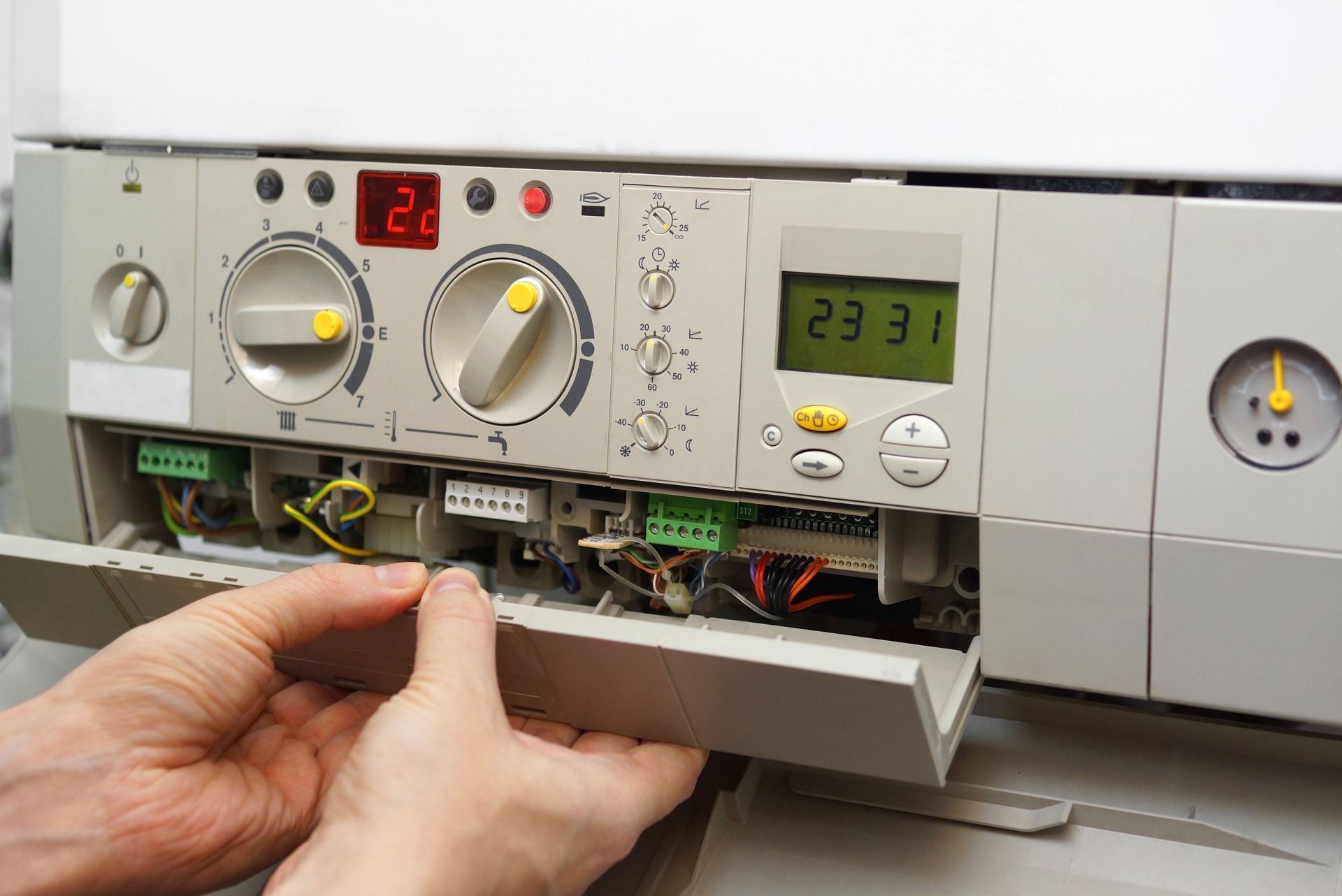 a person is fixing a boiler with their hands .