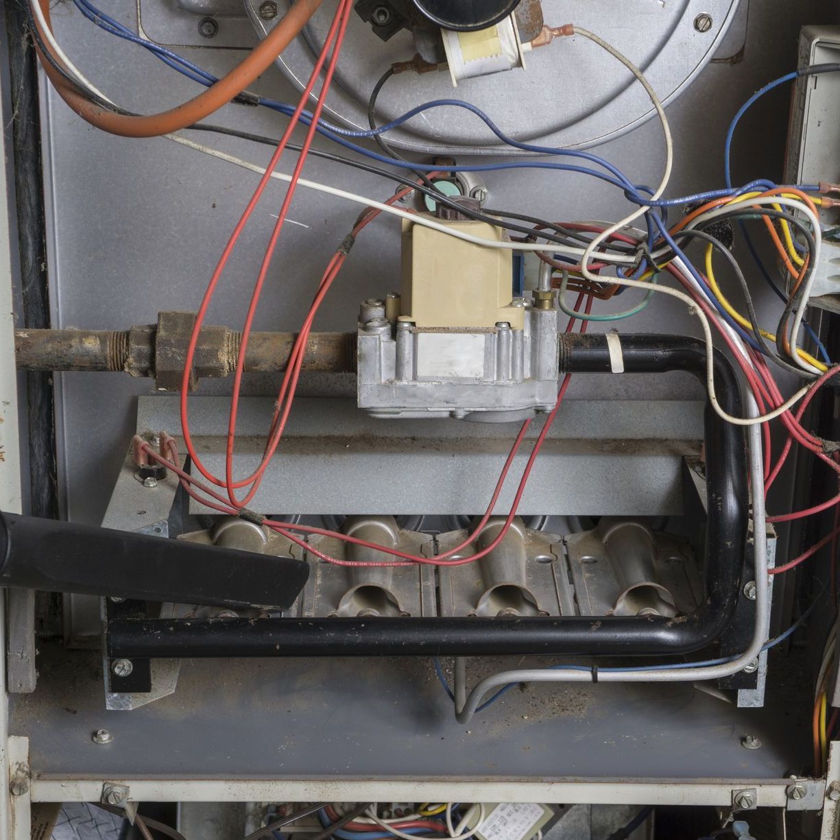 a vacuum cleaner is being used to clean the inside of a heating system .