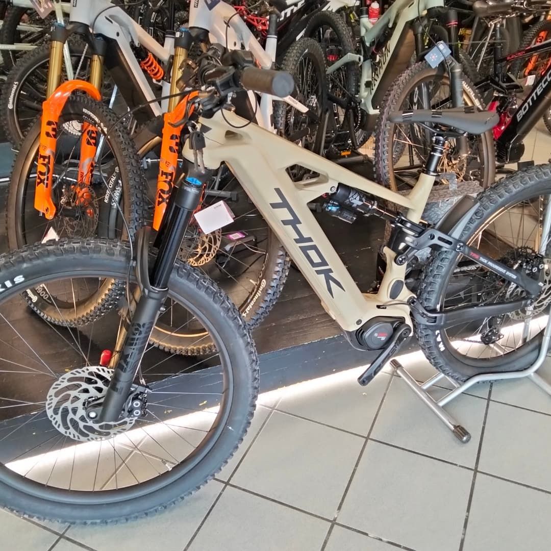 Mountain bike Athor con telaio beige e forcella nera esposta tra altre biciclette in un negozio