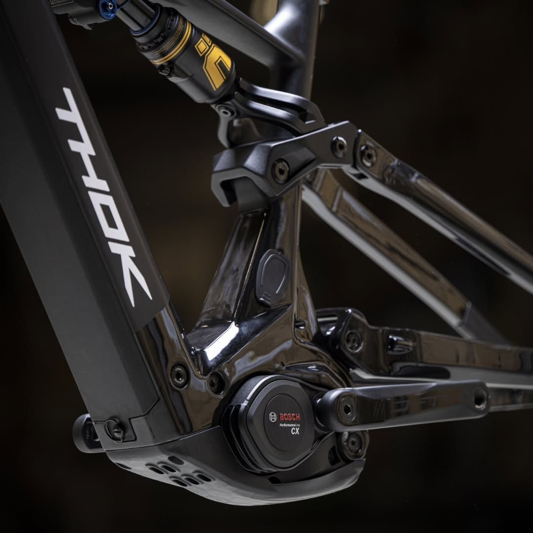 Primo piano del telaio di una bicicletta full-suspension nera e di un componente della trasmissione.