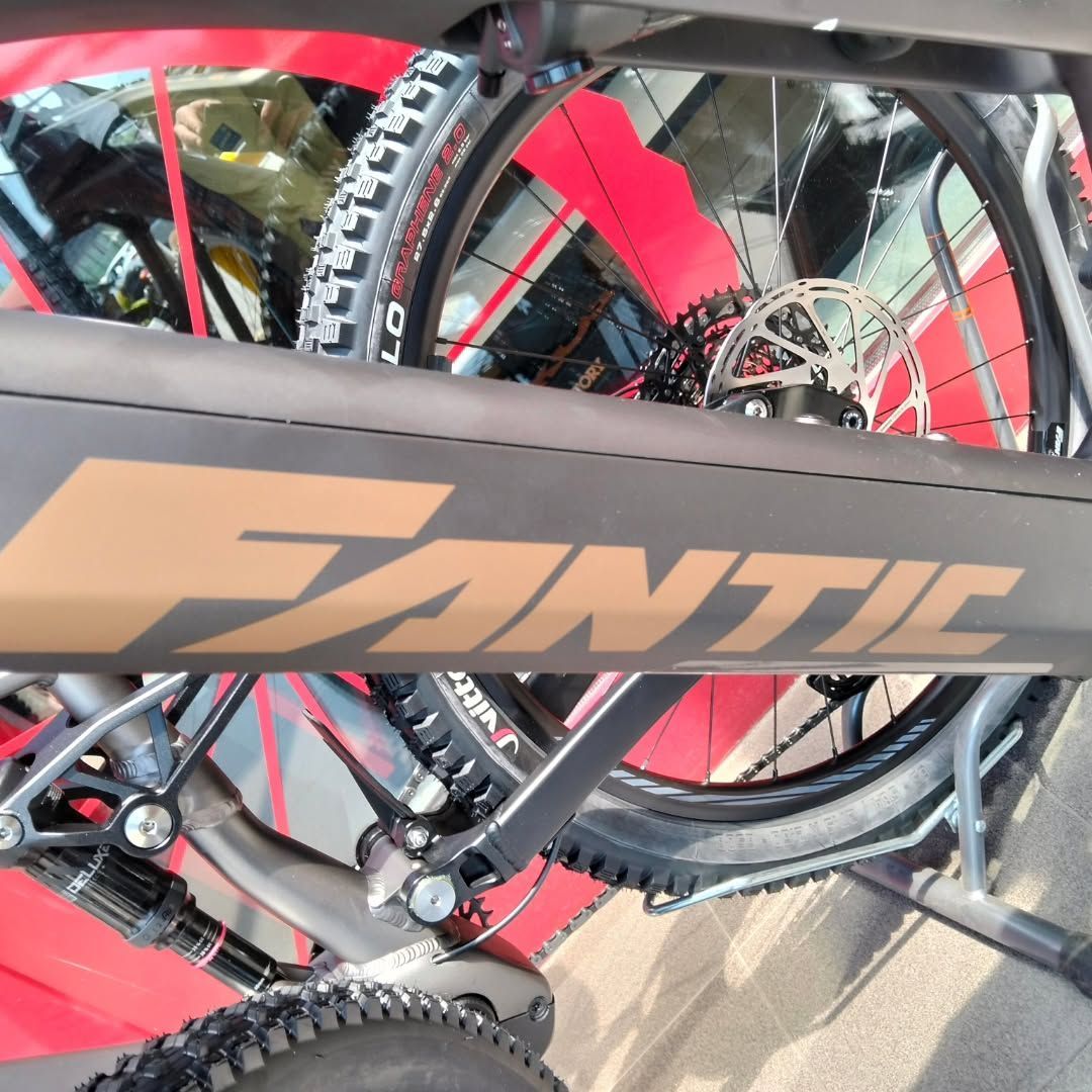 Primo piano del telaio e della ruota posteriore di una mountain bike Fantic rossa, completa di freno a disco e catena.