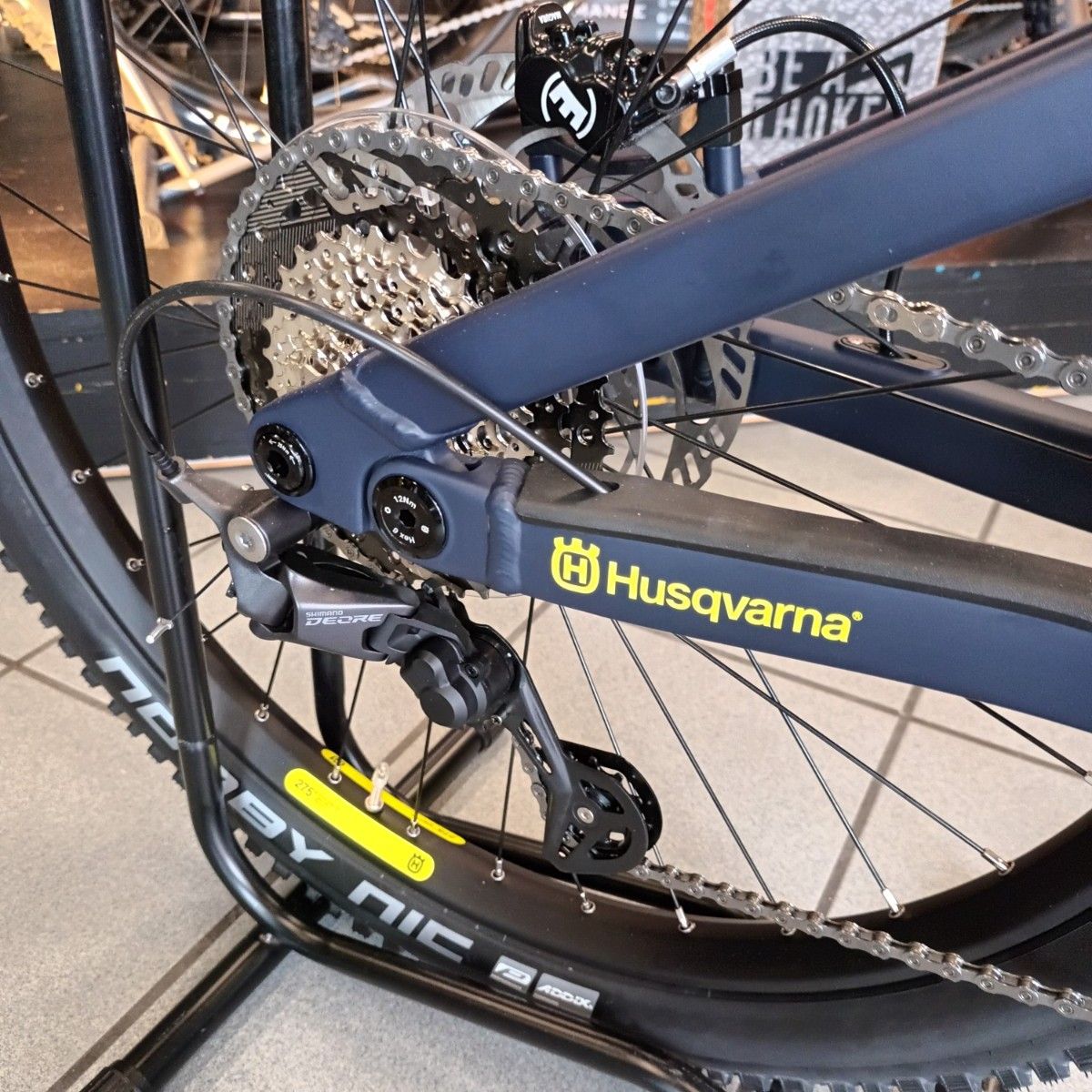 Primo piano della ruota posteriore, della catena e del deragliatore di una bicicletta Husqvarna blu.