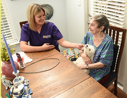 Caregiver assists person in wheelchair with meal on patio. Caregiver assists person in wheelchair with meal on patio.