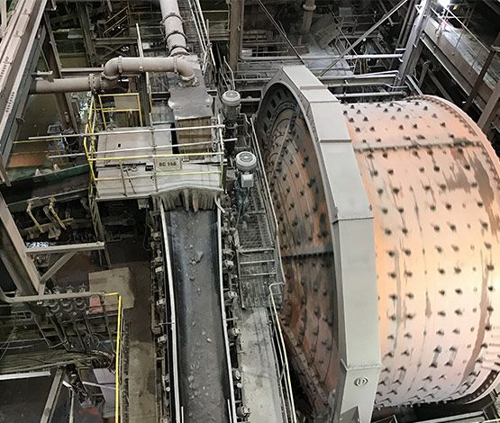 Technicien en équipement de protection soudant une structure métallique près d’un convoyeur industriel.