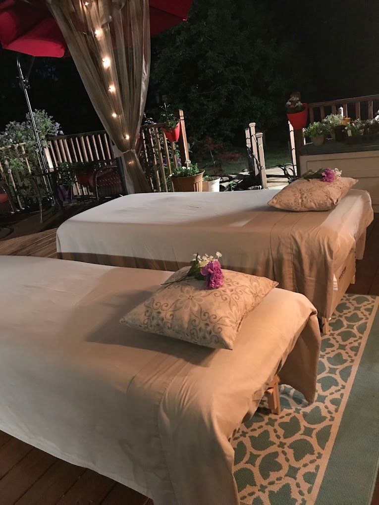 Two cushioned lounge beds with pillows on a patterned rug outdoors at night