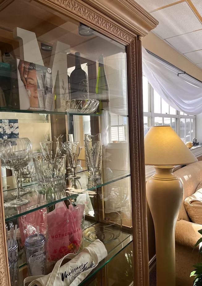 Glass display cabinet with crystal decor and a beige lamp in a bright room