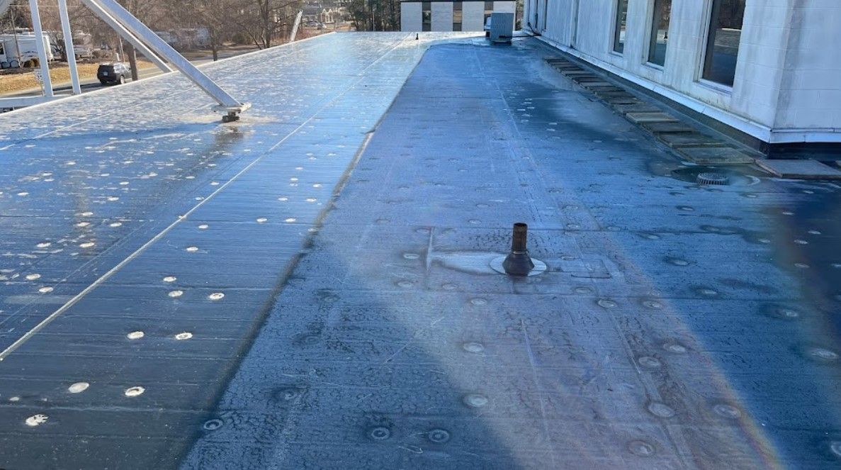 A roof with a hole in it and a drain on it.