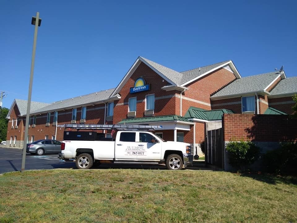 A white truck is parked in front of a brick building.