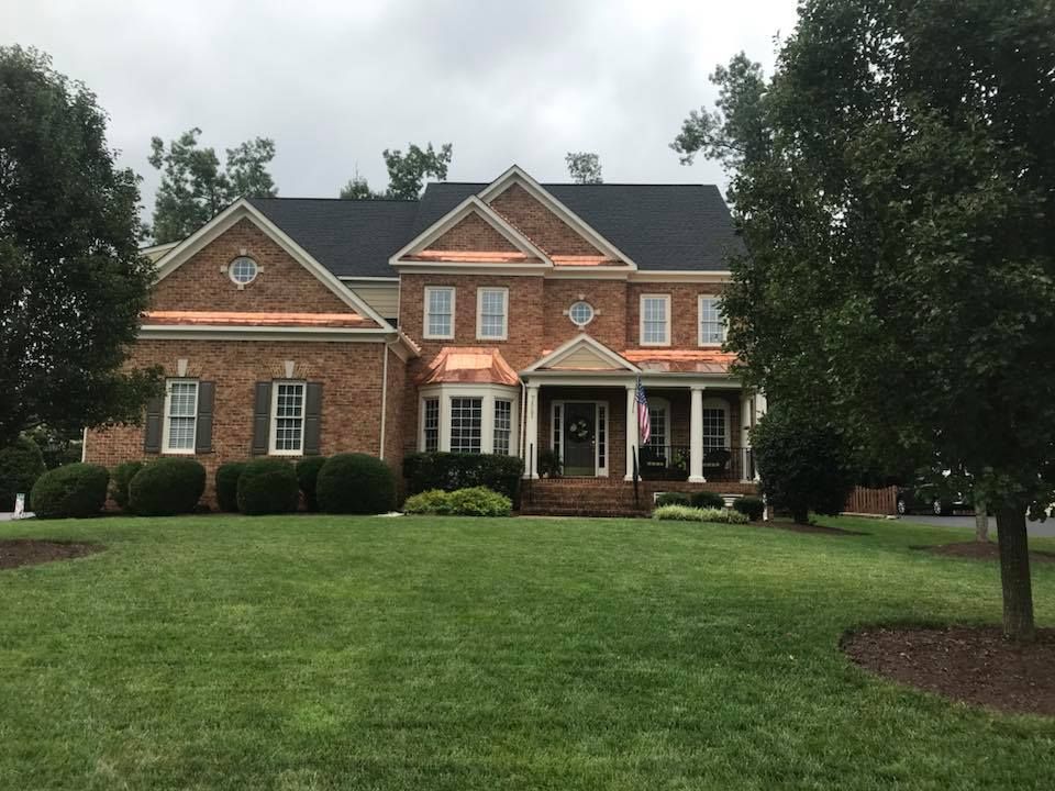 A large brick house with a large lawn in front of it