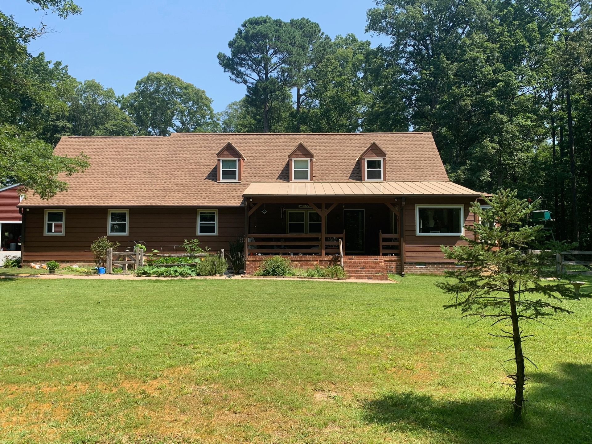 A large log cabin is sitting on top of a lush green field.