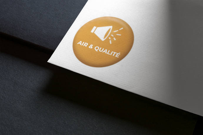 Autocollant jaune avec icône de mégaphone et texte « AIR & QUALITÉ » sur papier blanc.