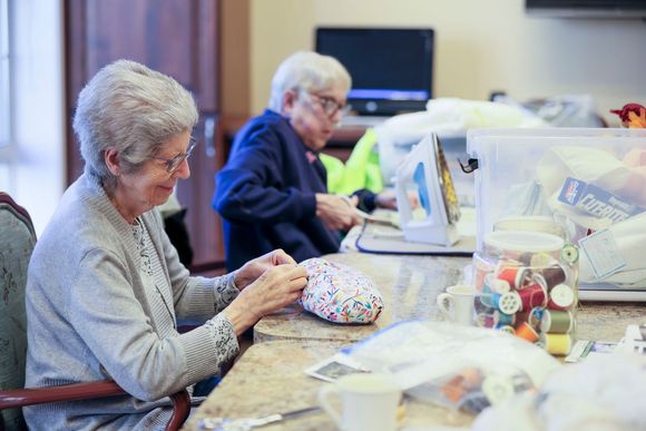 Smiling nurse standing with happy elderly male resident