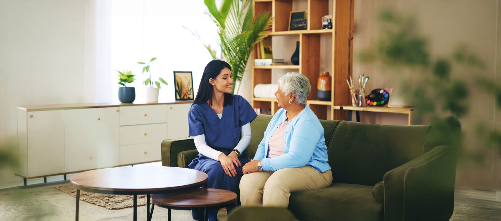 Caregiver and resident sharing a warm conversation at Riverside Commons Assisted Living