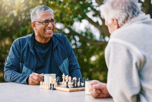 Caregiver holding hands with elderly woman in wheelchair outdoors