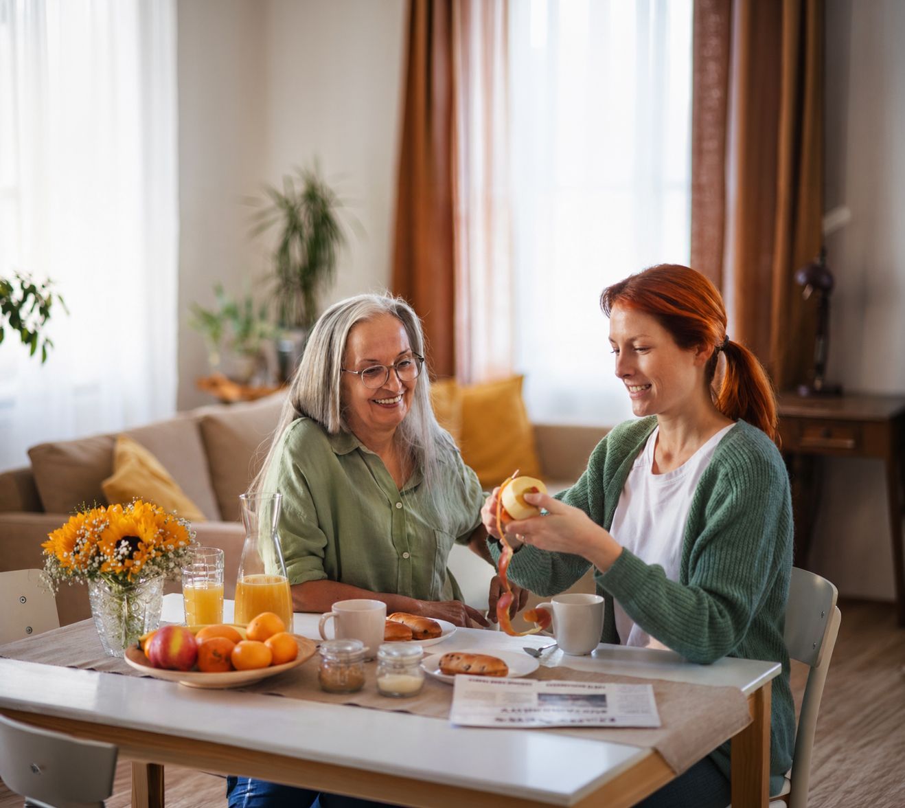 Caregiver providing medication management support to elderly couple at Riverside Commons assisted living