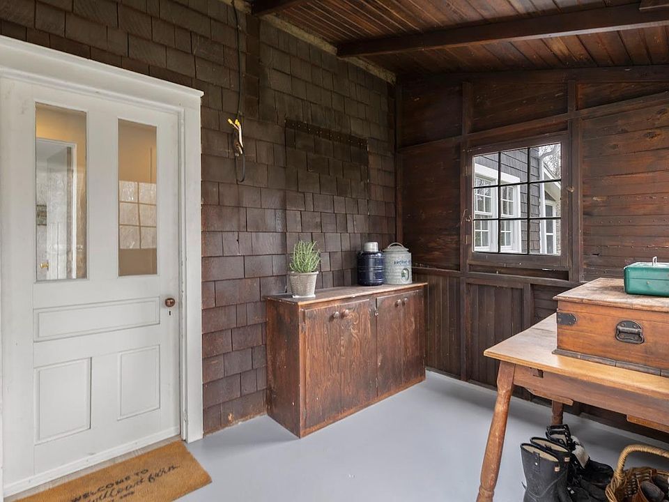 A wooden room with a white door and a wooden table.