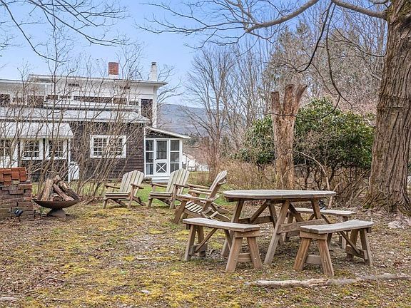 There is a picnic table and chairs in the backyard of a house.