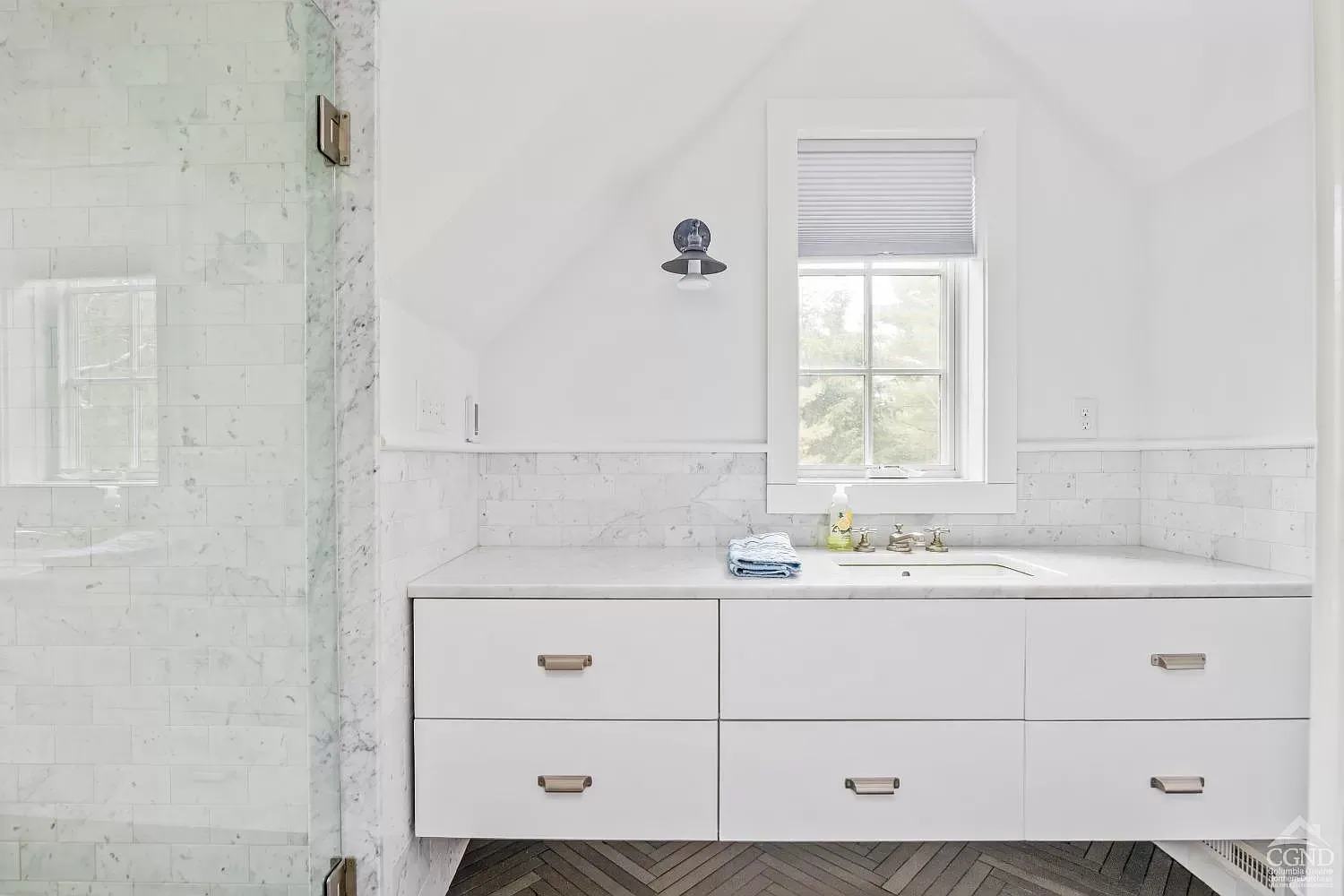 A bathroom with a sink , drawers , and a window.