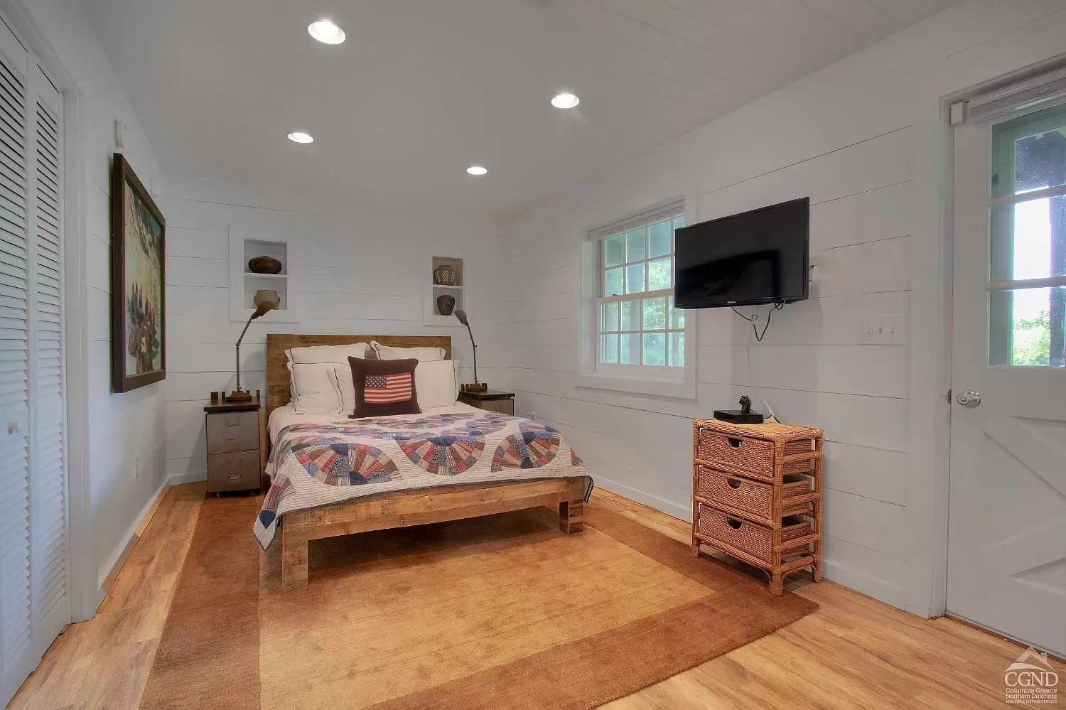 A bedroom with a bed , dresser , and television.