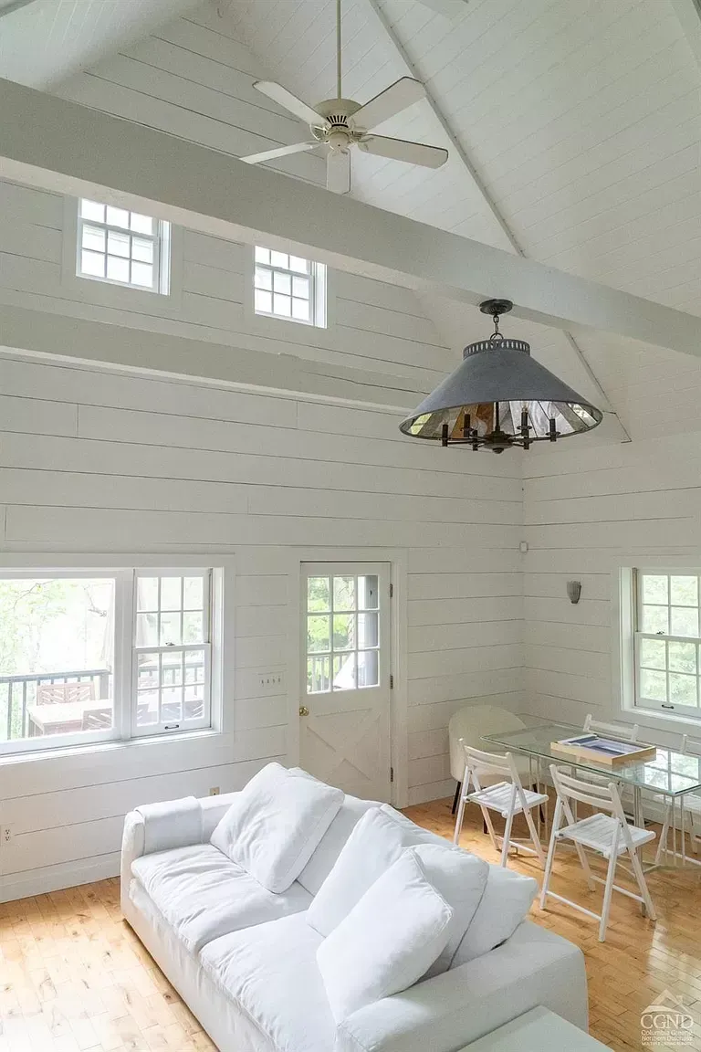 A living room with a white couch and a ceiling fan