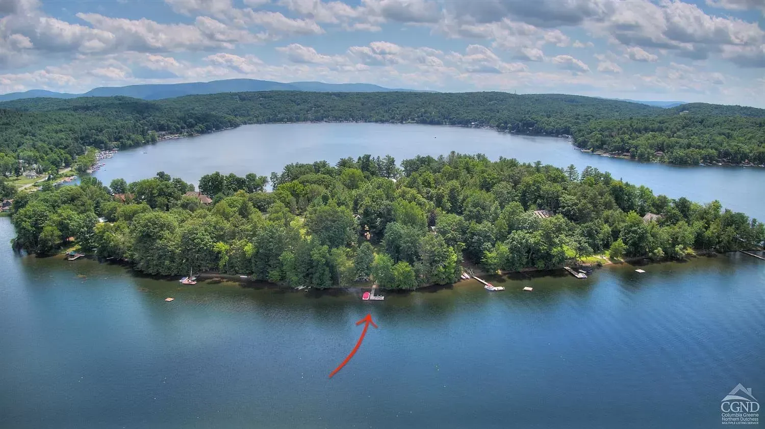 An aerial view of a small island in the middle of a lake surrounded by trees.