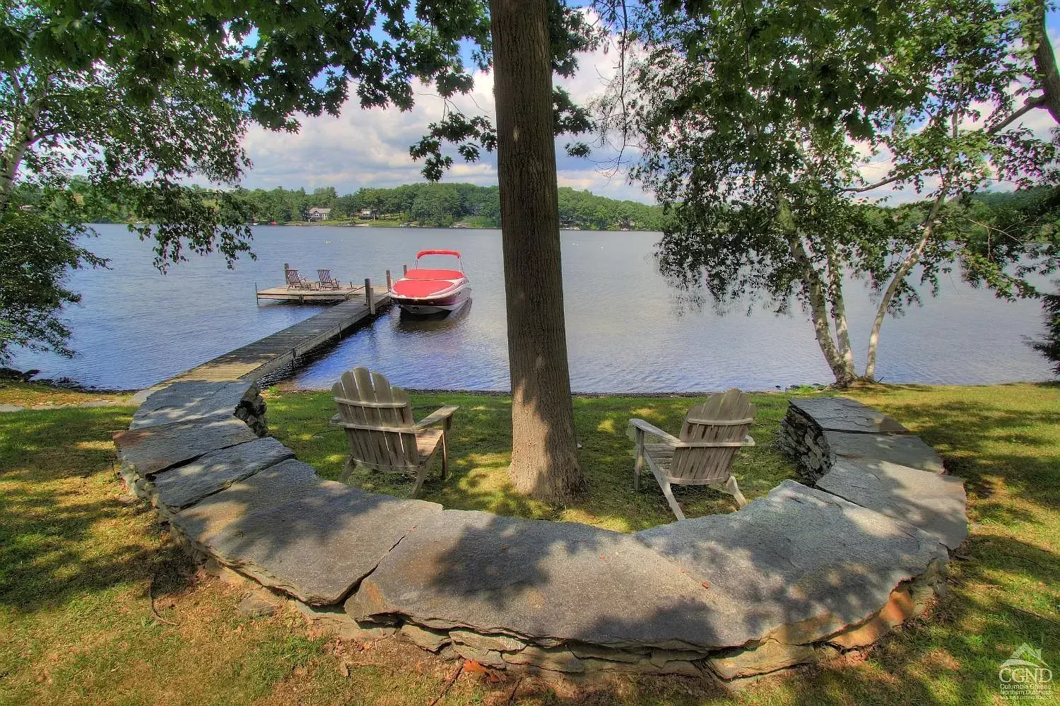 A boat is docked at a dock next to a lake.