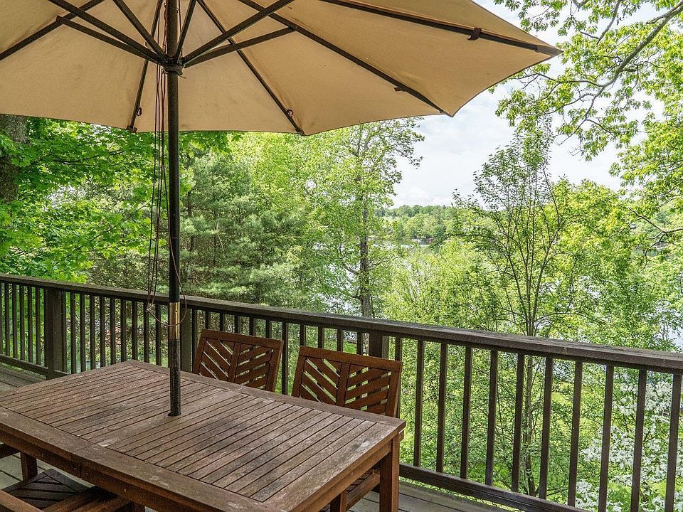 There is a table and chairs on the deck with an umbrella.