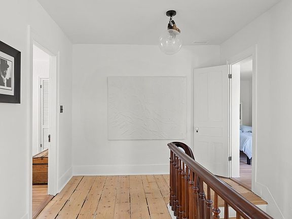 A staircase with a wooden railing and a white board on the wall.