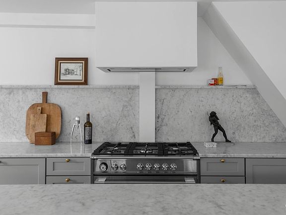 A kitchen with a stove top oven and a statue on the counter.