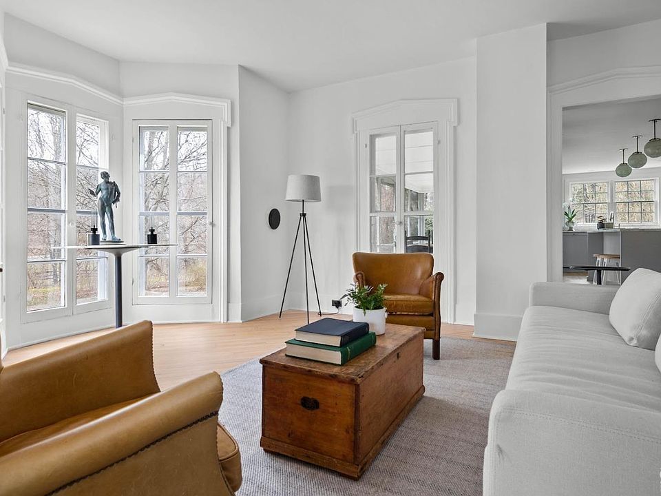 A living room with a couch , chair , coffee table , and lamp.