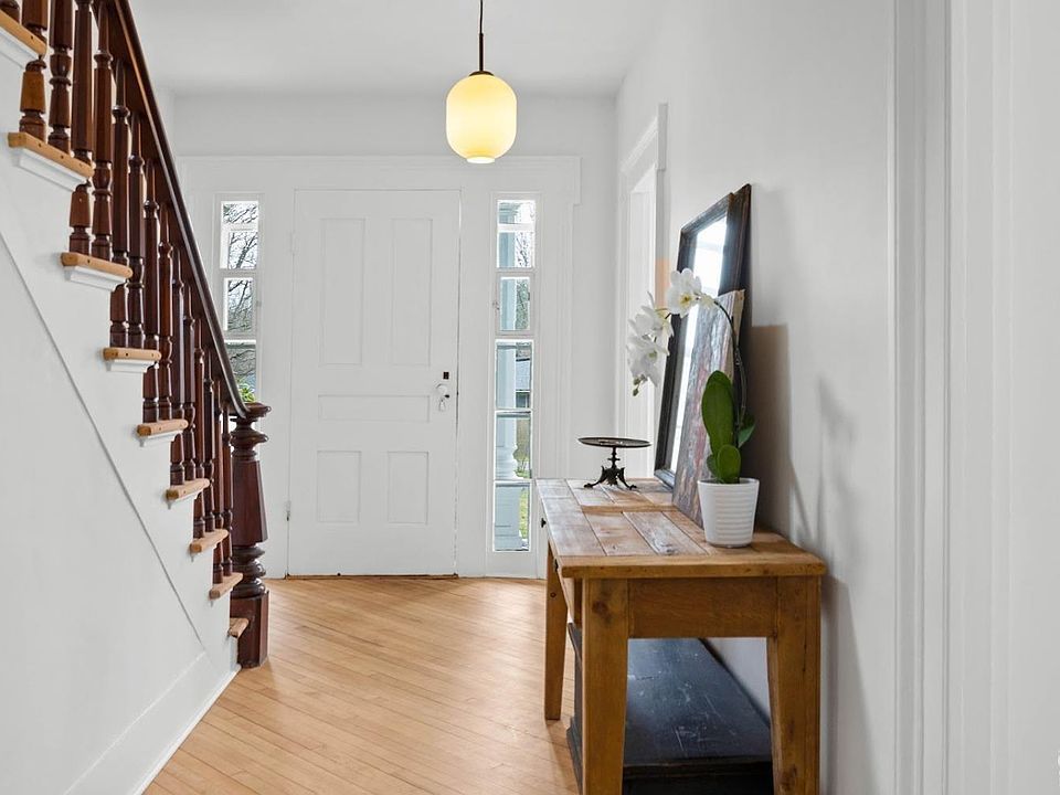 A hallway with a wooden table and stairs in a house.