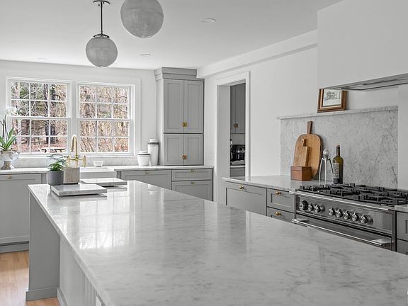 A kitchen with a large island and a stove top oven.