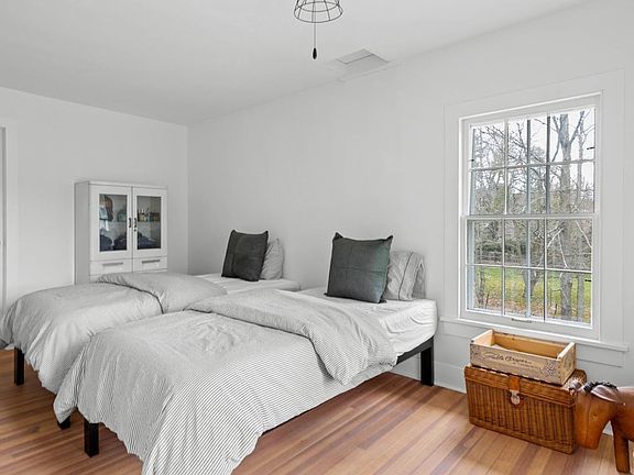 A bedroom with two beds and a window.