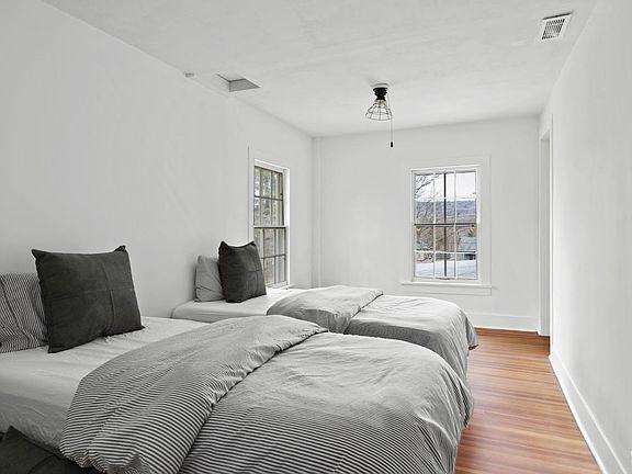 A bedroom with two beds and a window.