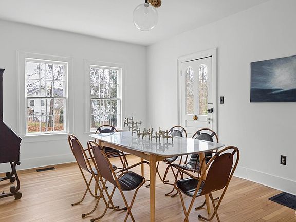A dining room with a table and chairs and a fireplace.