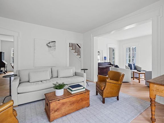 A living room with a couch , chairs , and a coffee table.