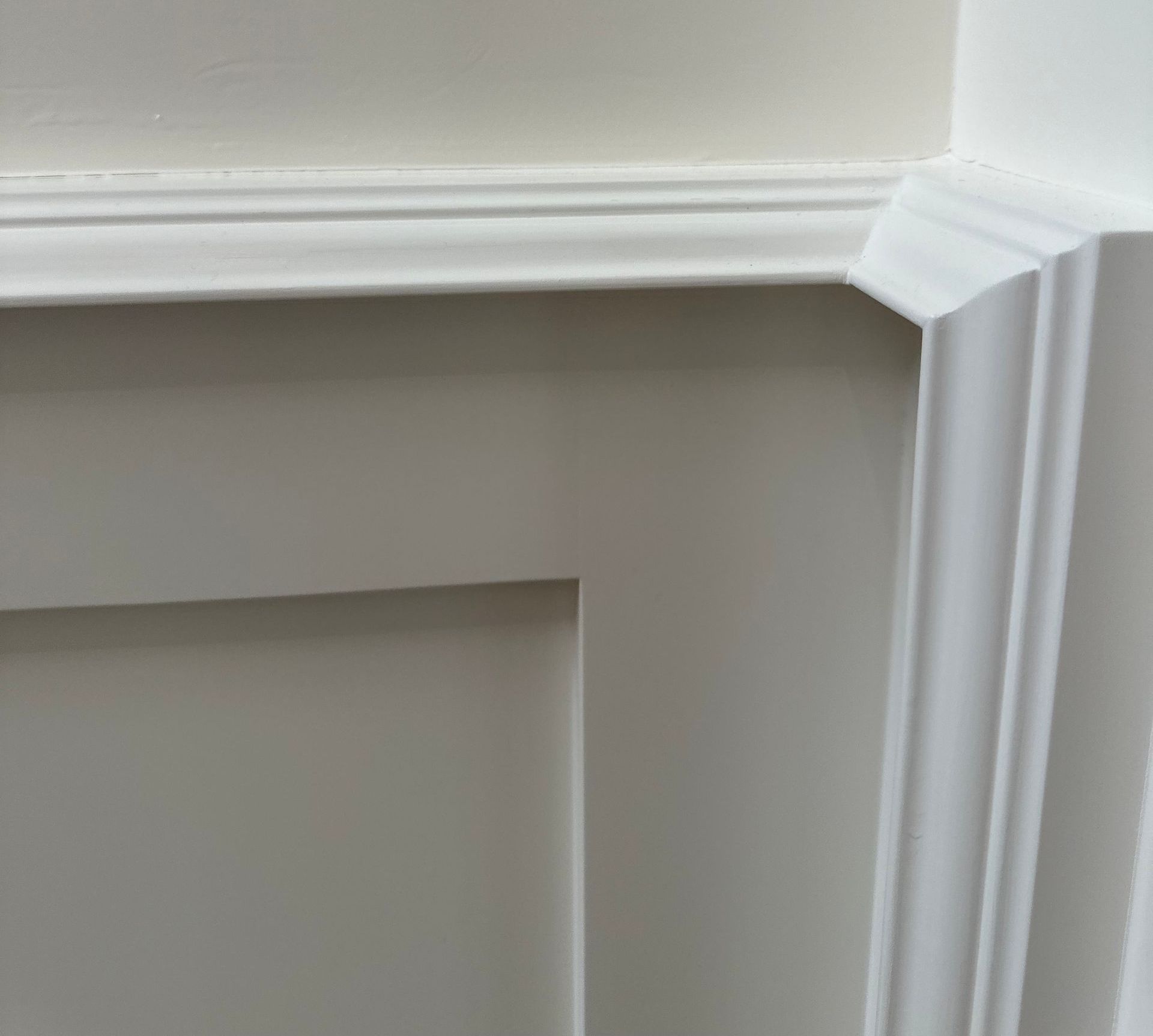 A close up of a white door with a white trim.
