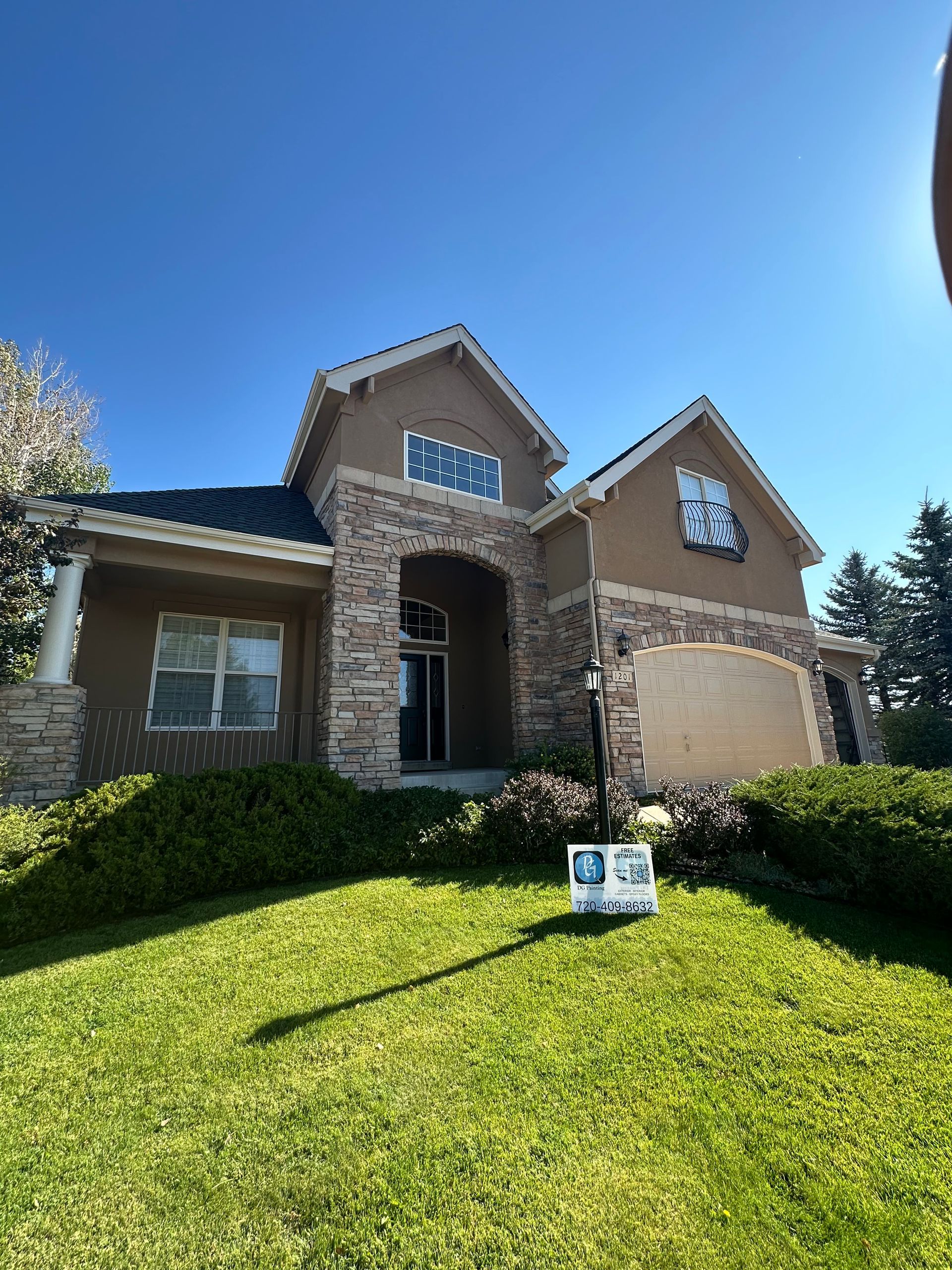 A large house with a for sale sign in front of it.