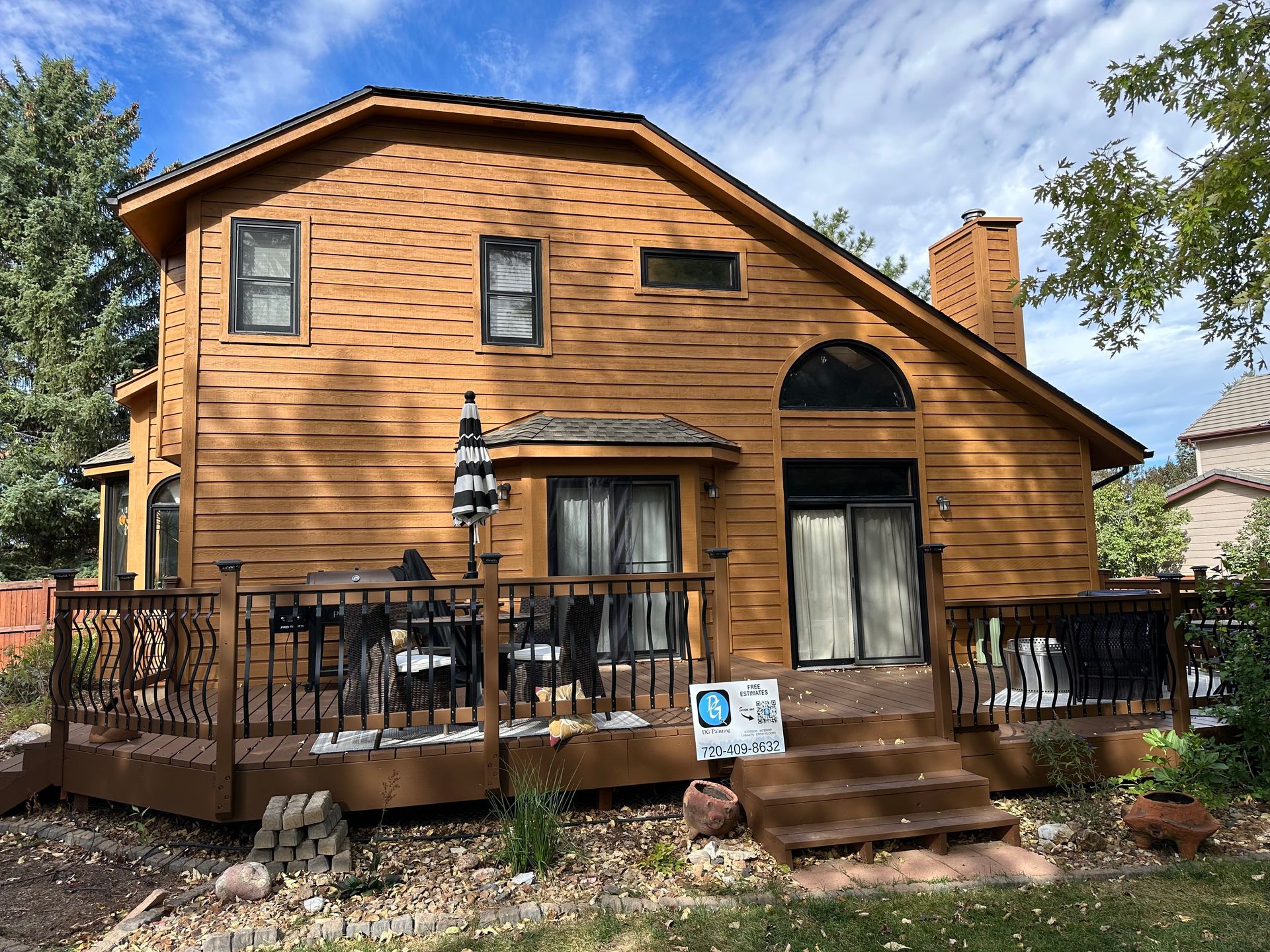 The back of a house with a large deck and stairs.
