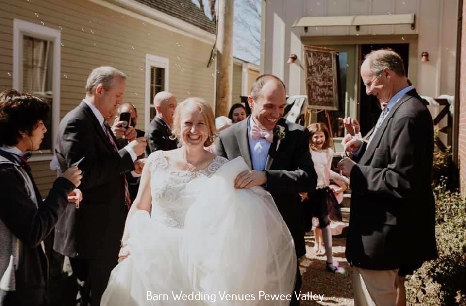 Bride and groom smiling while walking through guests after a wedding ceremony outdoors