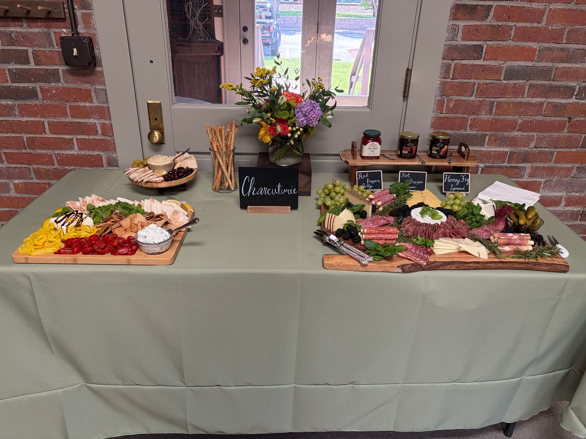 Charcuterie boards spread on a sage green linen table