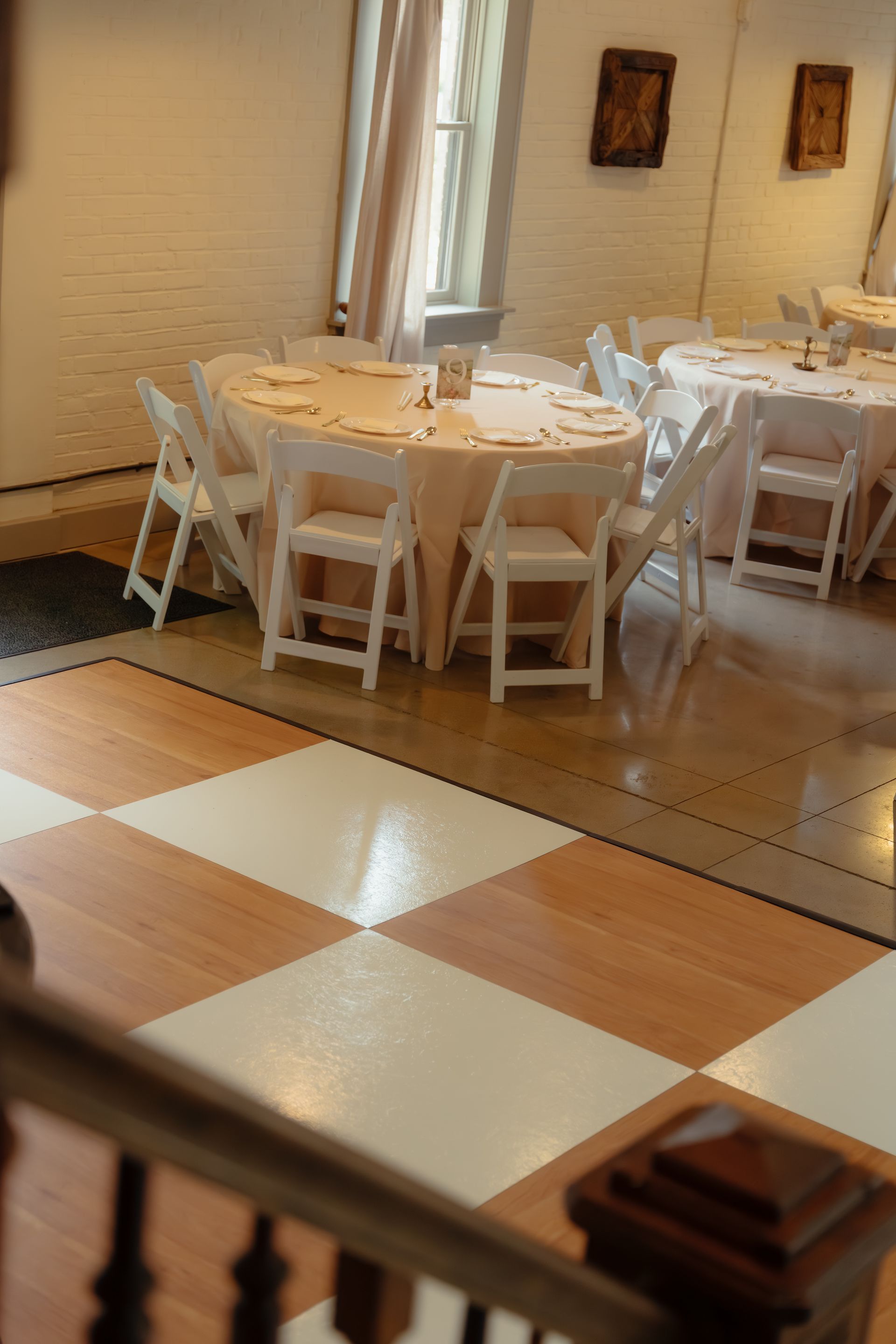 Checkered dance floor with white folding chairs staged nearby