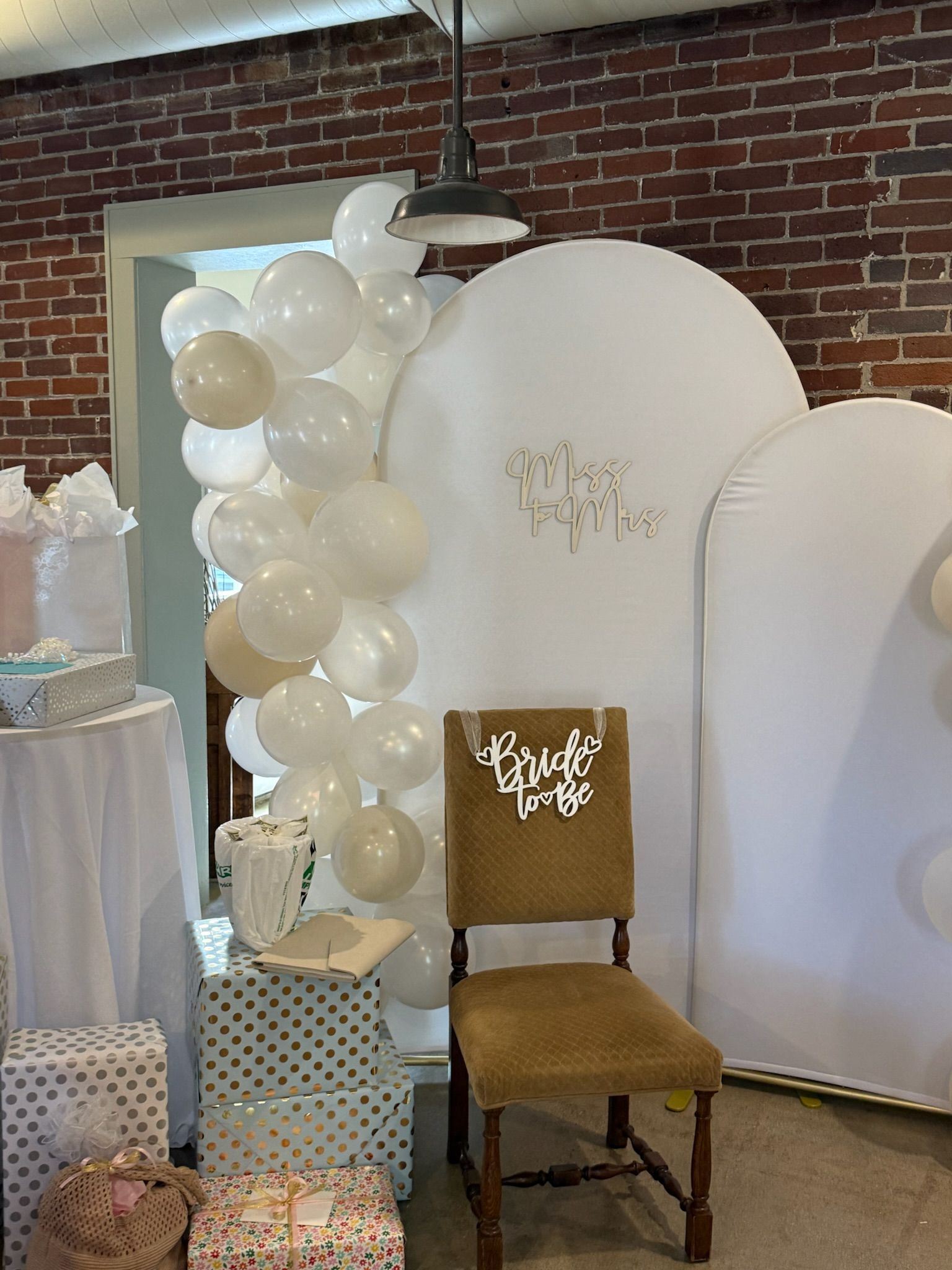 Bride-to-be chair with a Miss to Mrs sign and balloon garland