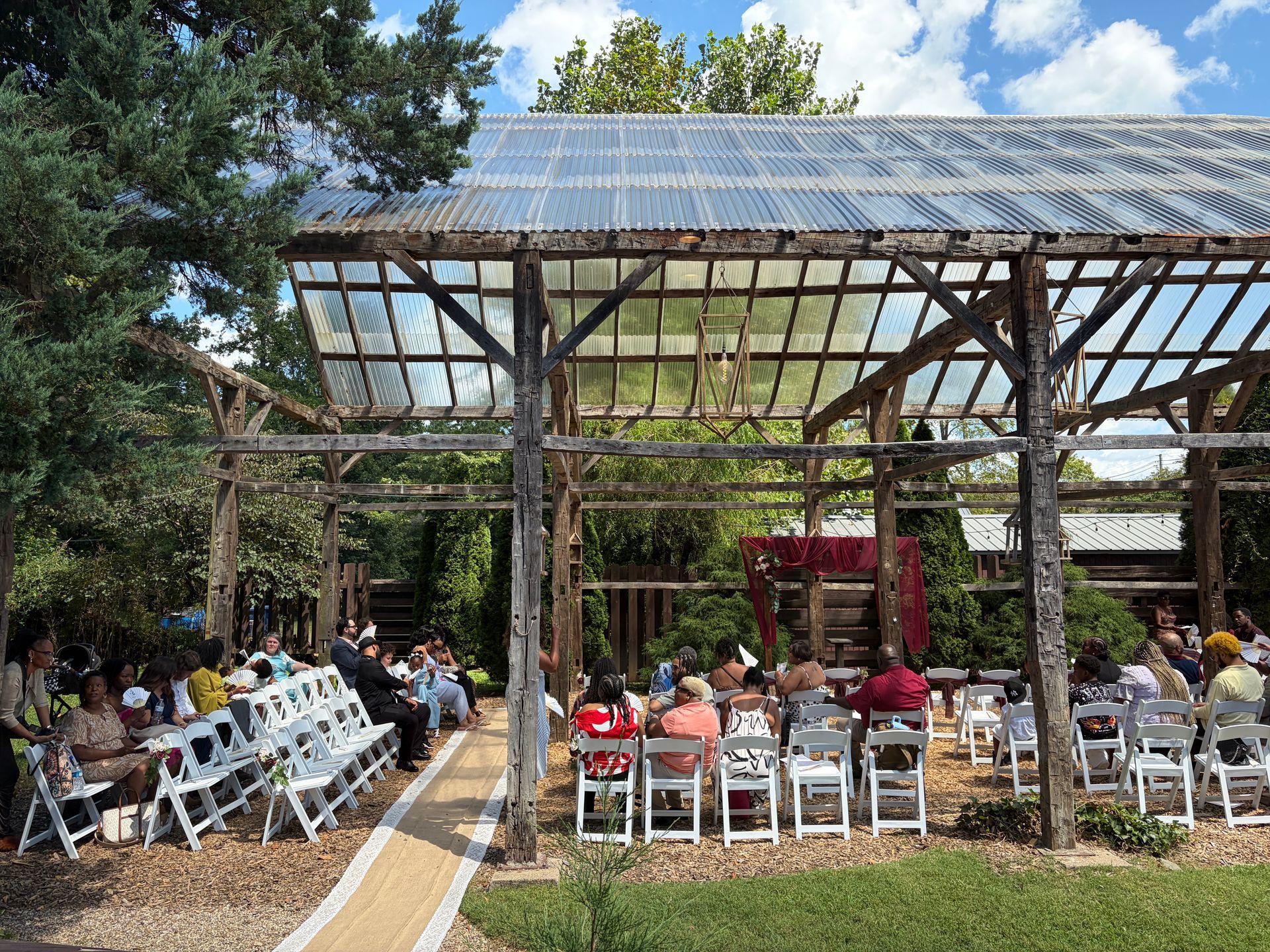 Outdoor pavilion ceremony dressed with red drapery for a fall wedding