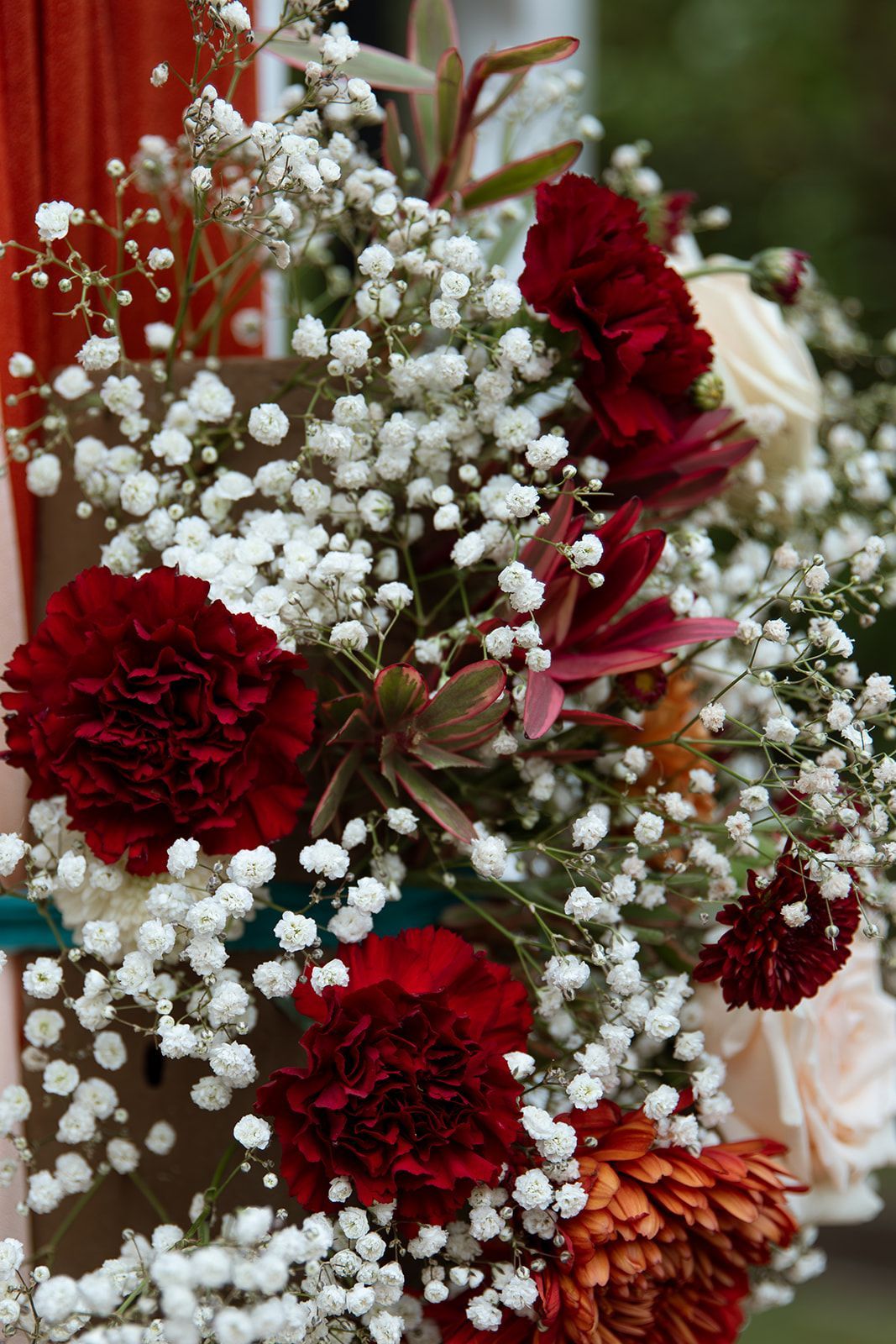 Close-up of red carnations and baby's breath floral arrangement