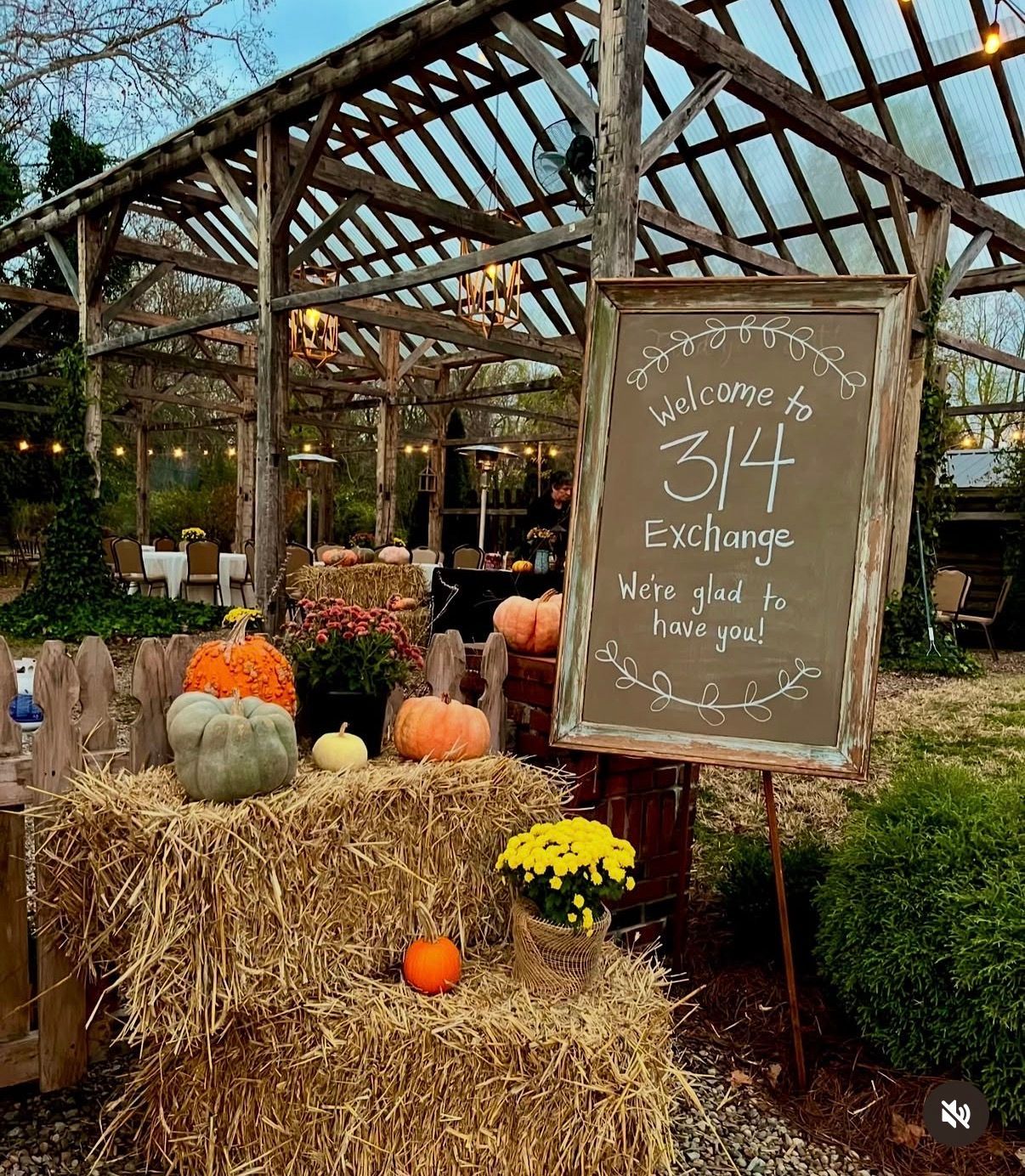 Fall welcome sign with pumpkins and hay bales in the evening