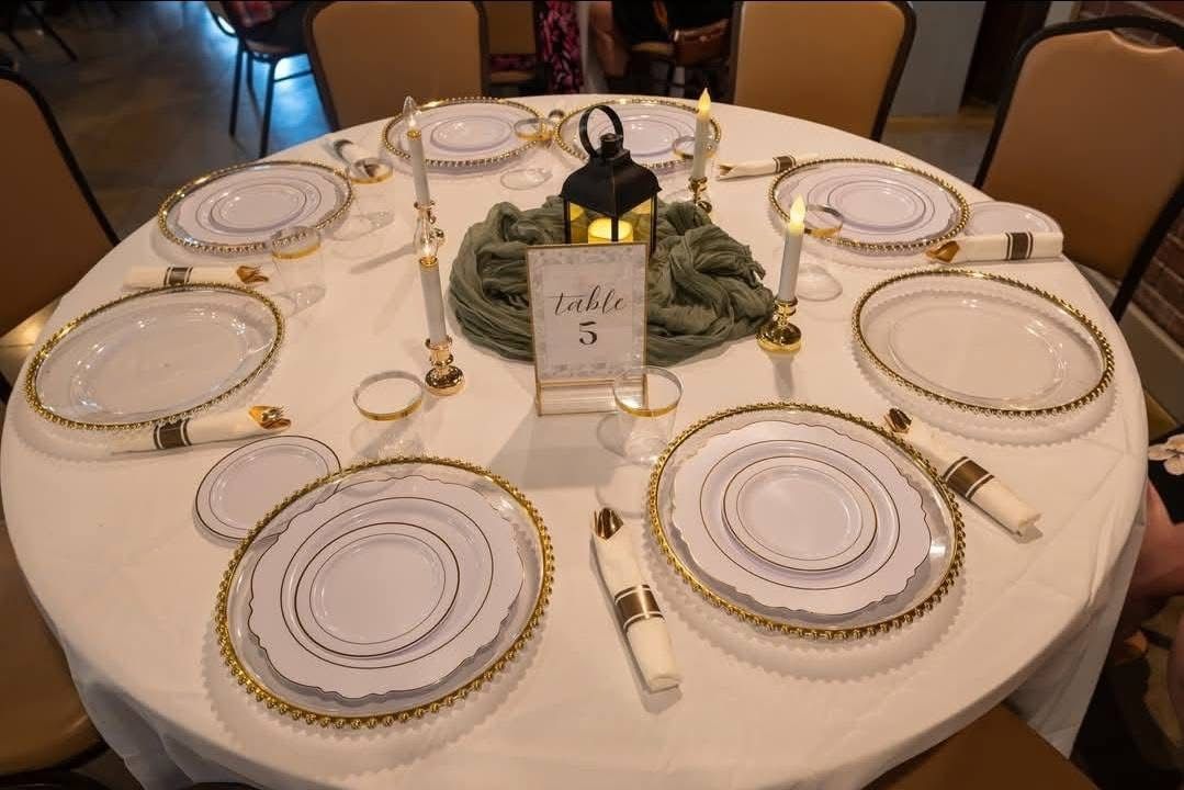 Reception table with gold beaded chargers and a sage green runner