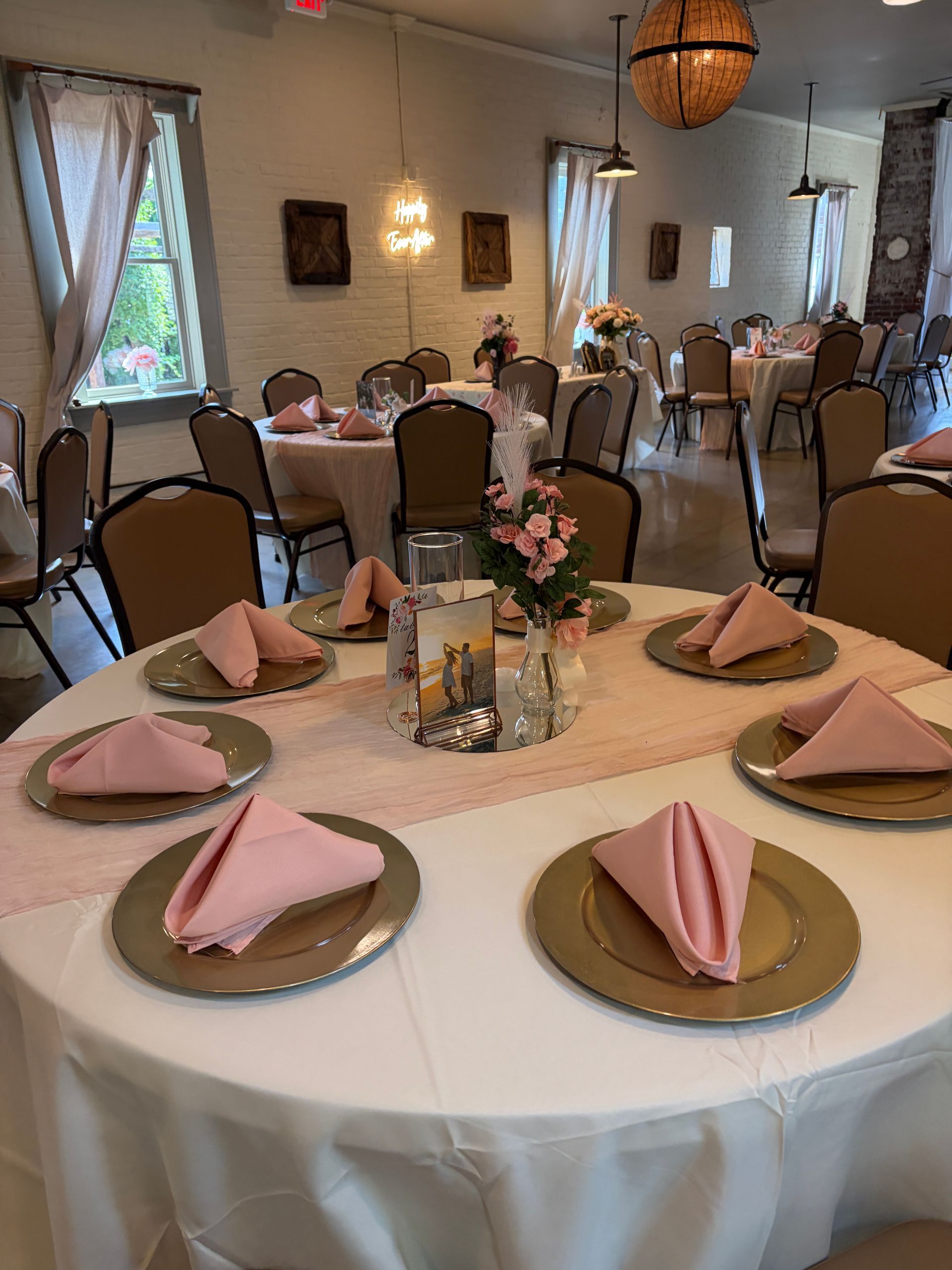 Reception table with gold chargers and blush pink napkins