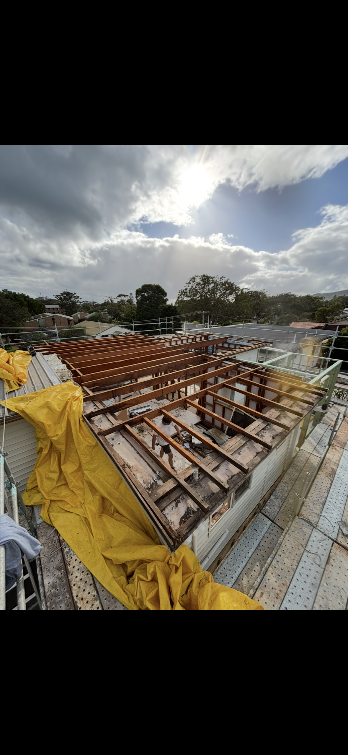 Person Building a Wooden Deck, Laying Planks Onto a Frame. Bare Legs and Hands Visible, Outdoors — Campbell Built in Nelson Bay, NSW